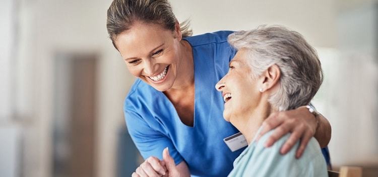Caring nurse with a senior in skilled nursing facility
