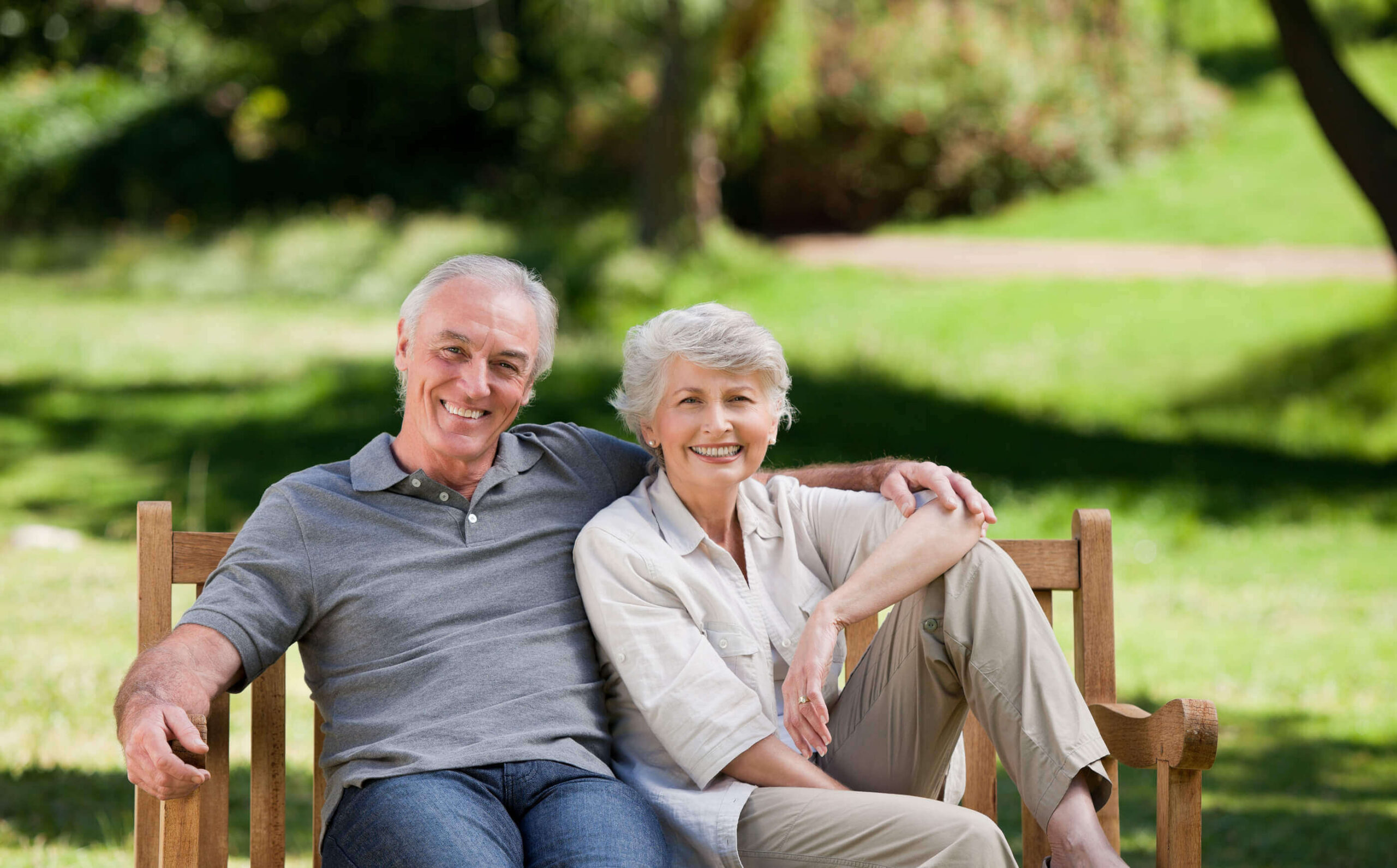 Senior couple sitting outside of their CCRC community.