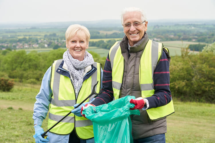 Senior couple cleaning up litter.
