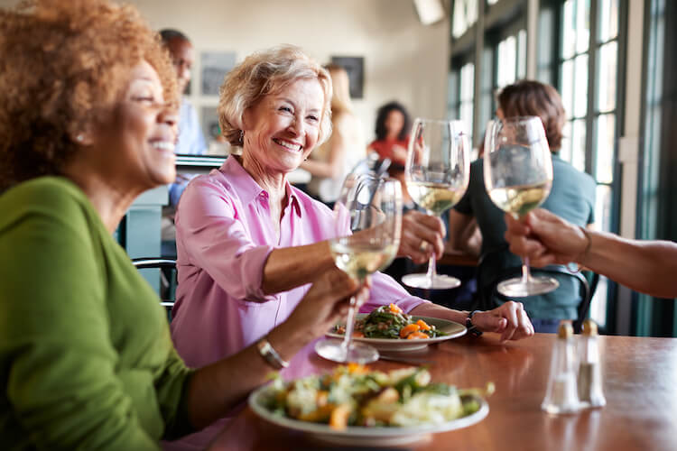 A group of seniors toast a meal.