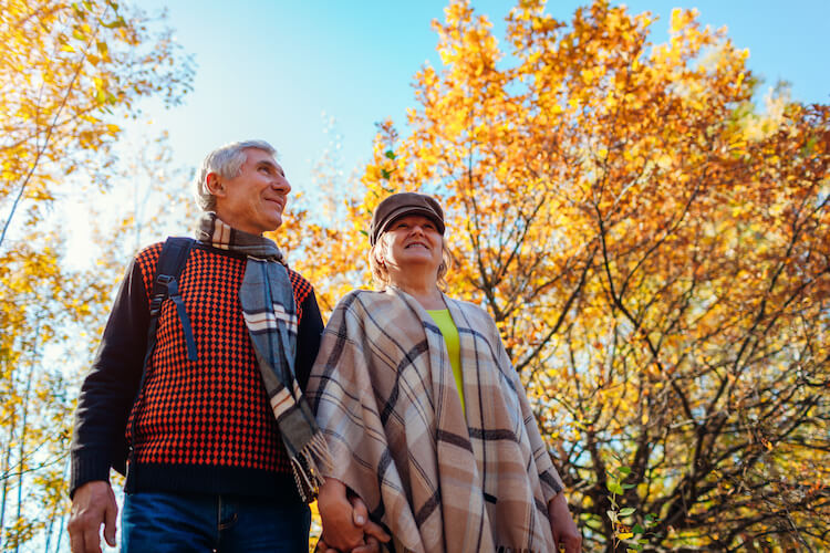 Senior couple walking on the ground of their independent living community.