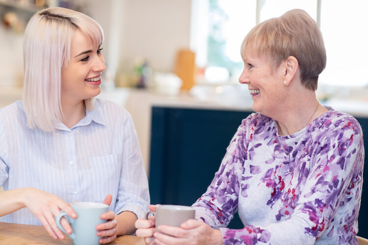 Senior woman speaking with sales counselor during her tour of a senior living community.