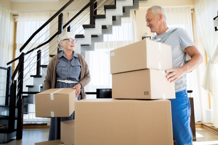 Happy senior couple packing their belongings to move to a new home.