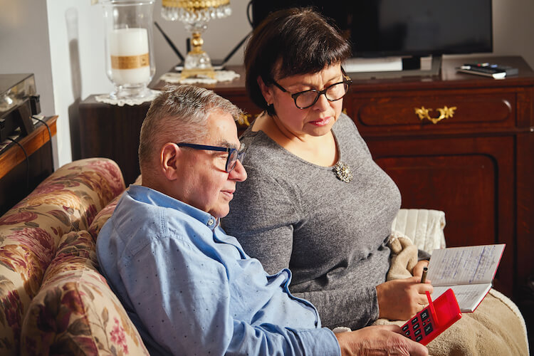 A senior couple considers the cost of retirement community living