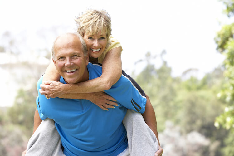 Happy senior couple exercising in park.