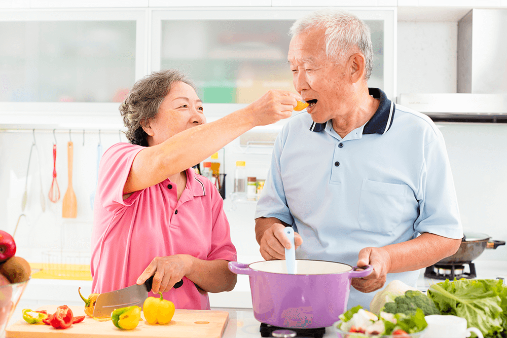 wife feeding husband fresh cut vegetable