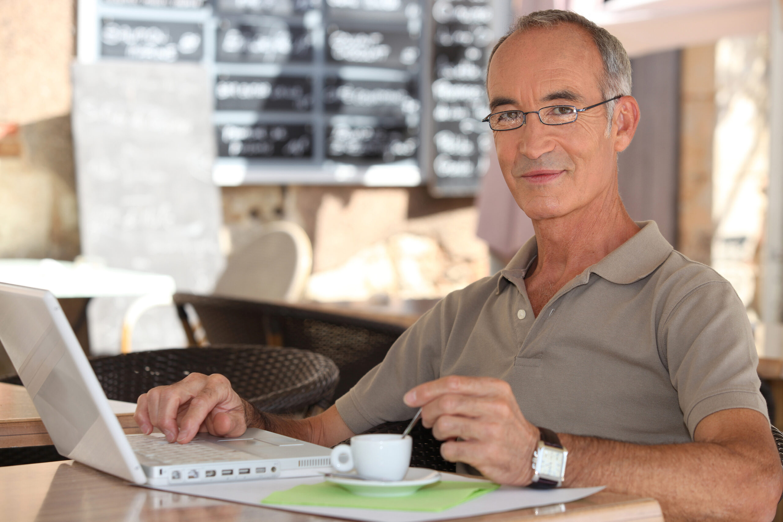 A senior man works on his computer.