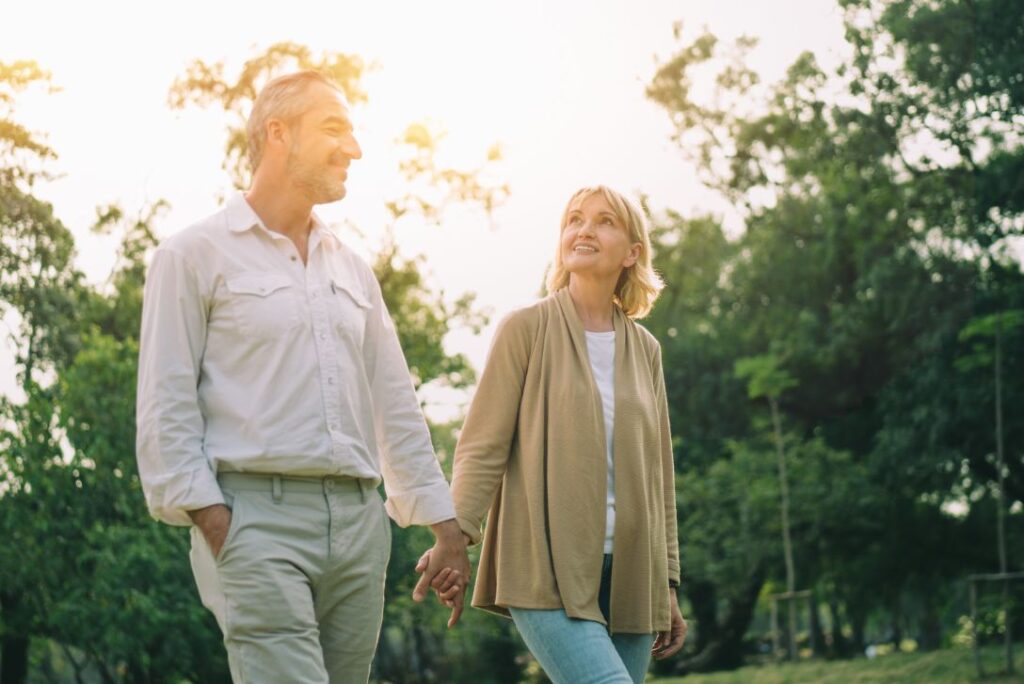 Senior couple walking in forest at sunset