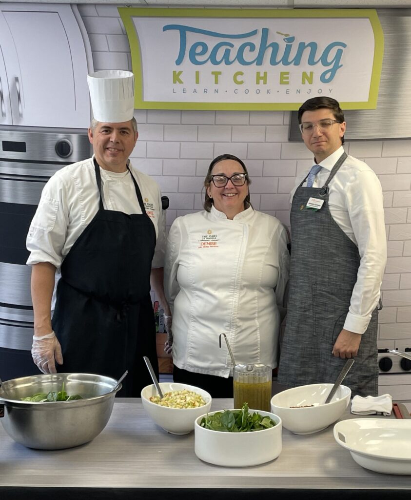Chefs standing in front of table with ingredients