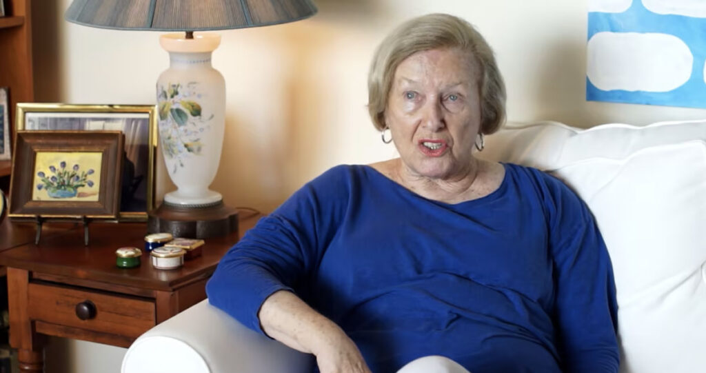 Woman in blue on couch talking about security
