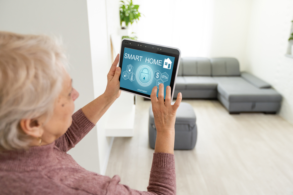 Senior woman uses smart tablet with her home