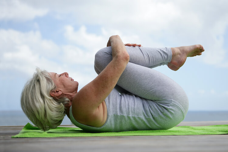 Senior woman practicing yoga, one of the best exercises for hips.