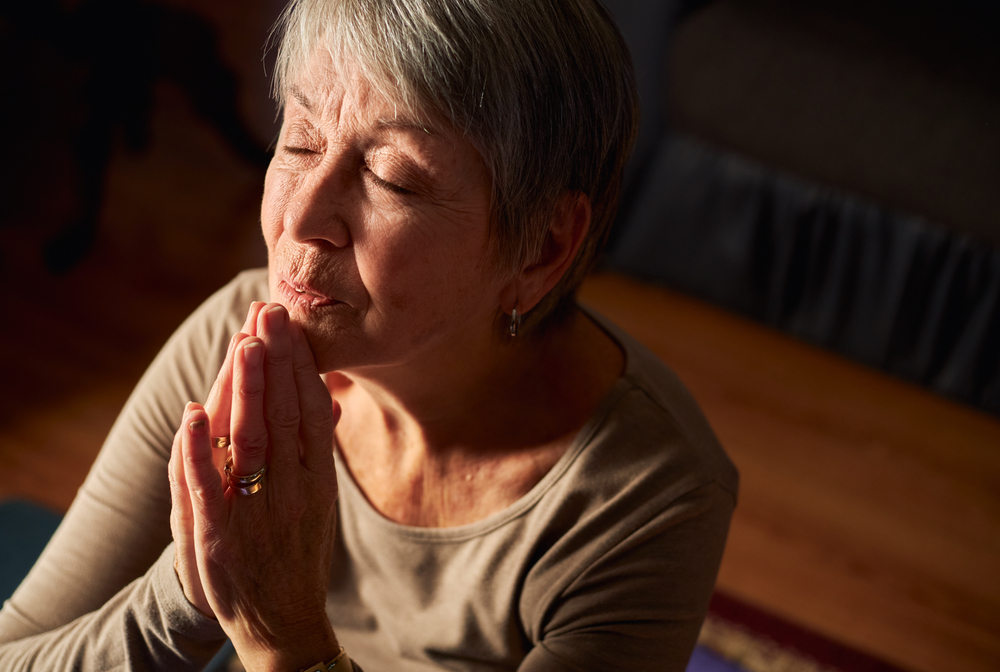 A senior woman praying