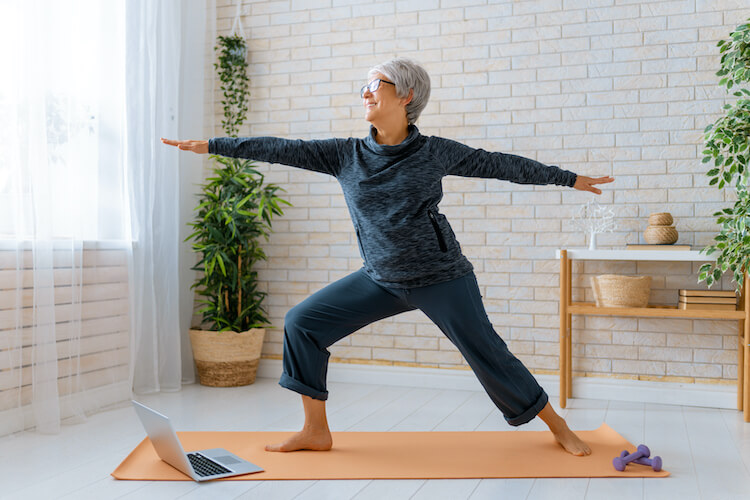A senior woman exercises at home.
