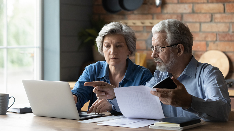 Senior couple sitting down and researching entrance fee communities.