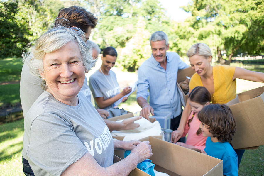 A senior woman volunteers her time to separate donations.