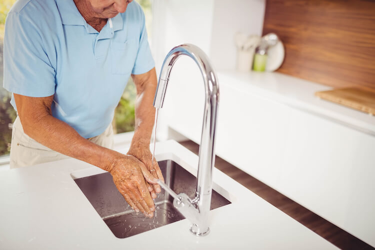 Senior man washing hands, a good personal hygiene practice.