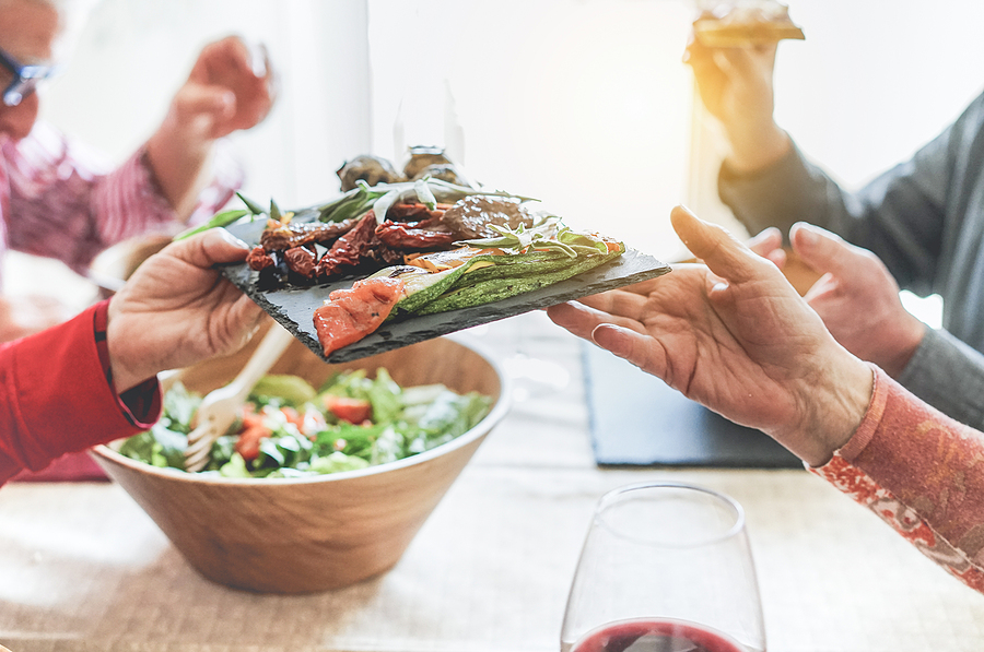 A group of older adults passing around a plate of healthy food