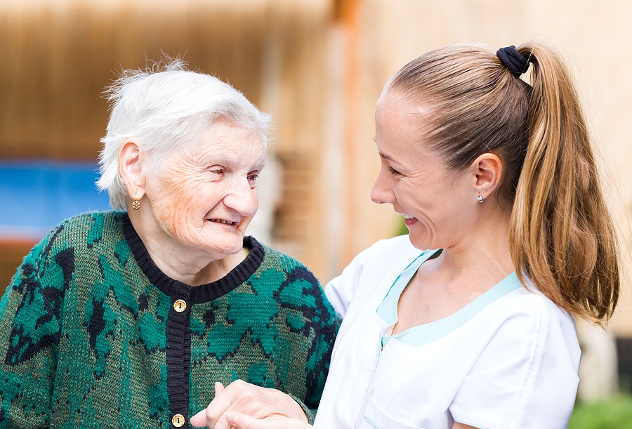 Memory Care Older woman in a memory care community smiling at younger woman