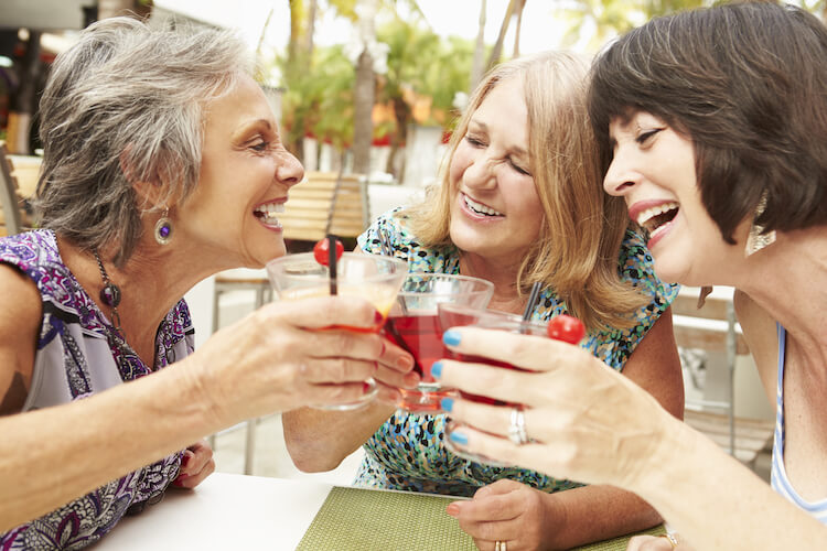 A group of older female friends enjoying a cocktail together.