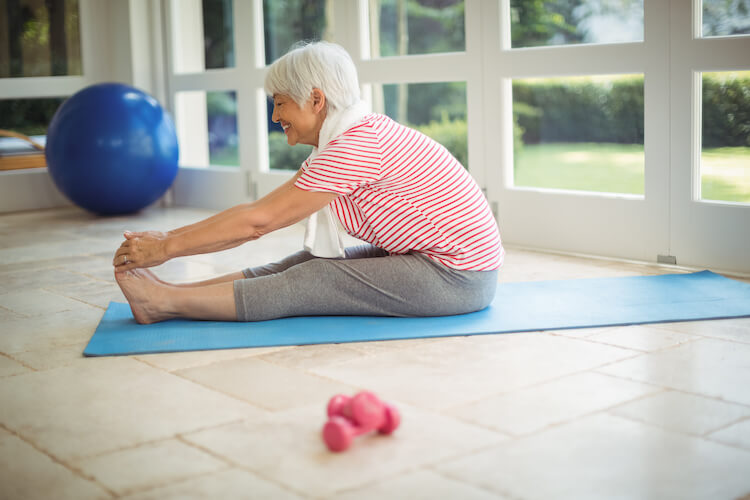 Senior woman performing a stretching exercise to improve balance.