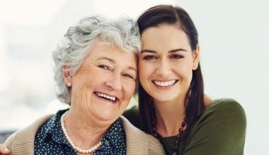 Resident and adult daughter smiling at camera