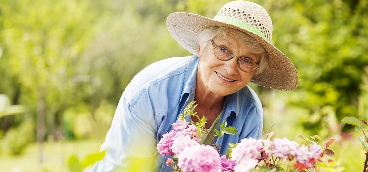 Senior woman enjoying a day in her garden and connecting to her environment